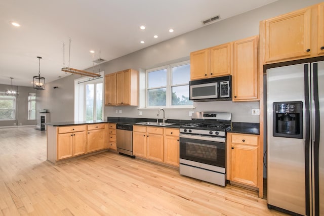 2901 W Washington Blvd Unit 2, Chicago, IL 60612 - kitchen with stainless steel appliances, dark countertops, a peninsula, light wood-style floors, and recessed lighting