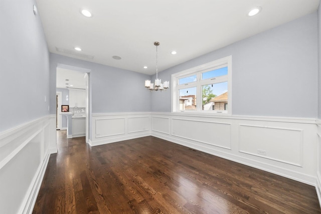 2040 N Laporte Ave, Chicago, IL 60639 - unfurnished dining area with a chandelier, recessed lighting, a wainscoted wall, dark wood finished floors, and a decorative wall
