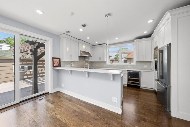 2040 N Laporte Ave, Chicago, IL 60639 - kitchen with wine cooler, high quality fridge, a kitchen breakfast bar, light countertops, and a peninsula