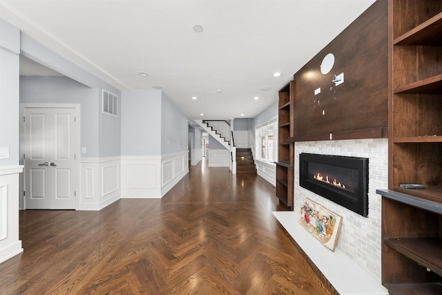 2040 N Laporte Ave, Chicago, IL 60639 - unfurnished living room with stairway, a glass covered fireplace, and a wainscoted wall