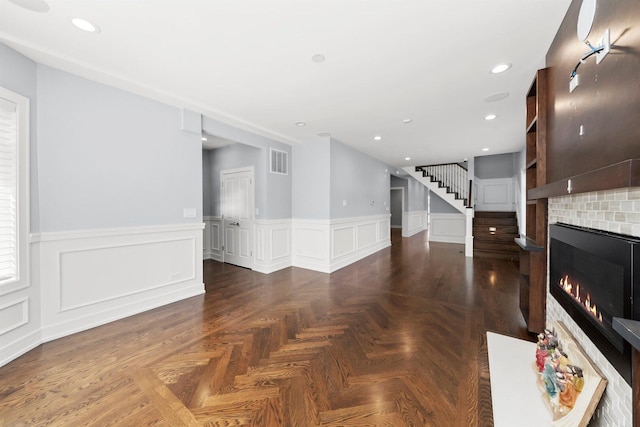 2040 N Laporte Ave, Chicago, IL 60639 - unfurnished living room with a tile fireplace, stairway, wainscoting, recessed lighting, and a decorative wall