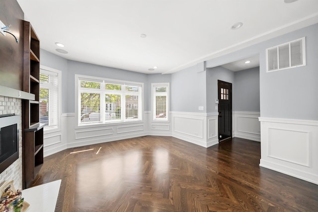 2040 N Laporte Ave, Chicago, IL 60639 - unfurnished living room with a brick fireplace, a wainscoted wall, recessed lighting, and a decorative wall