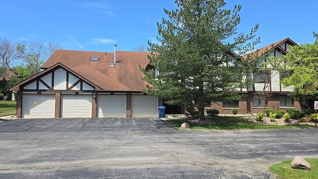 906 E Steger Rd Unit 5, Crete, IL 60417 - tudor home featuring brick siding, asphalt driveway, and an attached garage