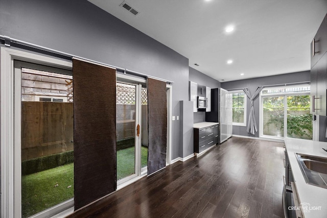 3312 W Beach Ave Unit 1, Chicago, IL 60651 - kitchen featuring dark wood-style floors, stainless steel microwave, light countertops, recessed lighting, and modern cabinets