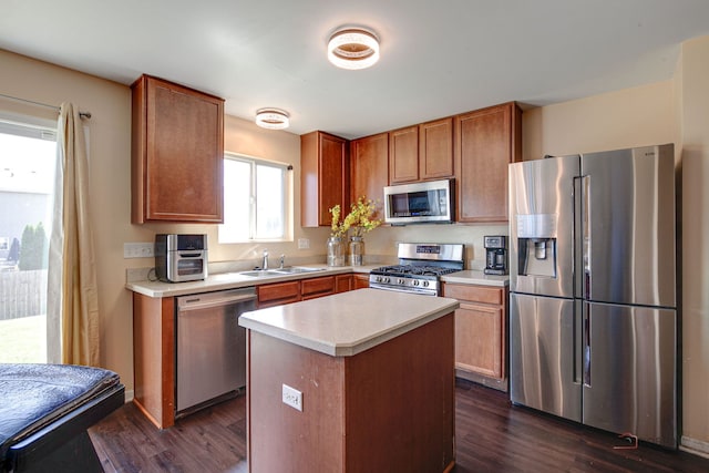 39837 N Torry Ln, Beach Park, IL 60083 - kitchen with appliances with stainless steel finishes, light countertops, dark wood-style flooring, a center island, and brown cabinets