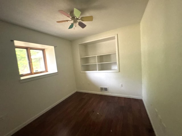 10440 Hussung Dr, Rock Falls, IL 61071 - spare room featuring dark wood-style floors, a ceiling fan, and built in features