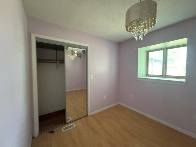 10440 Hussung Dr, Rock Falls, IL 61071 - unfurnished bedroom with wood finished floors, a chandelier, and a closet