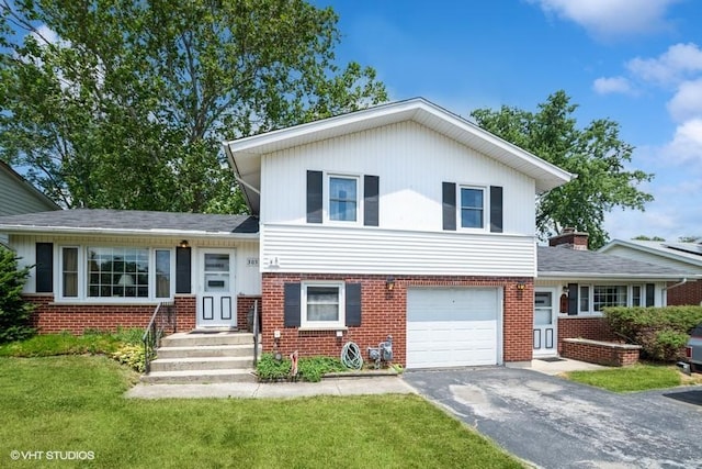 305 Milburn Ave, Crete, IL 60417 - split level home with brick siding, asphalt driveway, a garage, and a front lawn