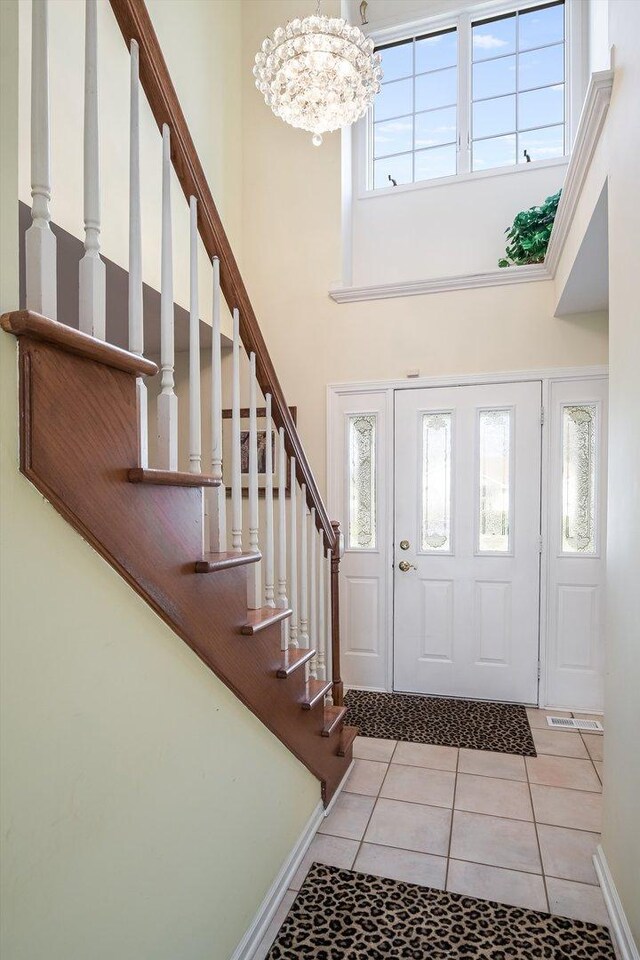 18036 Crystal Ln, Lansing, IL 60438 - foyer entrance featuring a towering ceiling, a chandelier, stairs, and light tile patterned flooring