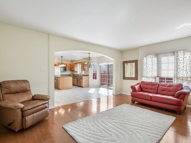 18036 Crystal Ln, Lansing, IL 60438 - living room with arched walkways, light wood-type flooring, and a chandelier