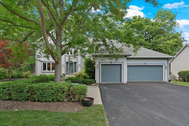7488 Bittersweet Dr, Gurnee, IL 60031 - obstructed view of property with asphalt driveway, an attached garage, stucco siding, and roof with shingles