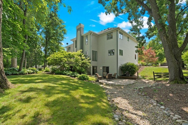 7488 Bittersweet Dr, Gurnee, IL 60031 - back of house with a chimney, a lawn, and a patio area