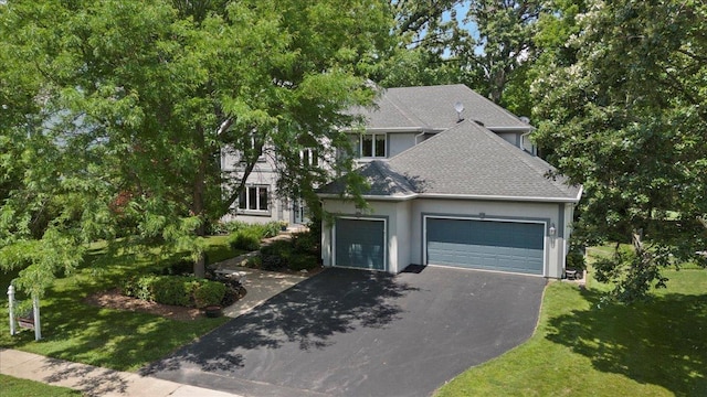 7488 Bittersweet Dr, Gurnee, IL 60031 - view of front facade with asphalt driveway, an attached garage, a front yard, stucco siding, and roof with shingles