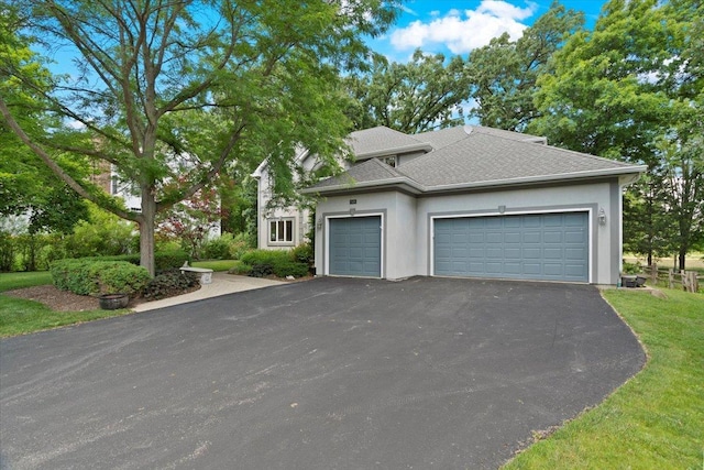 7488 Bittersweet Dr, Gurnee, IL 60031 - view of front of home featuring driveway, a garage, stucco siding, a shingled roof, and a front yard