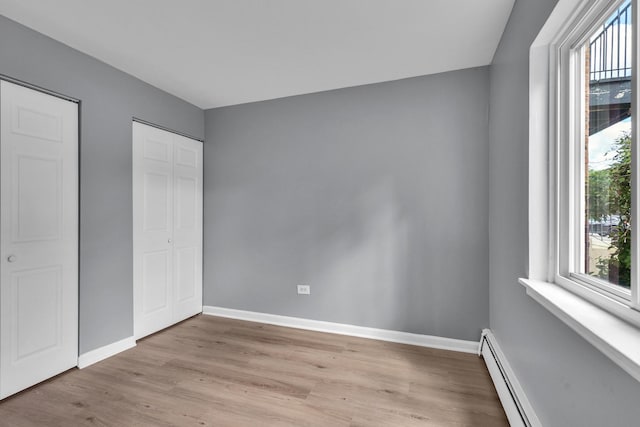 6 E Dundee Quarter Dr Unit 101, Palatine, IL 60074 - unfurnished bedroom featuring light wood-style flooring, baseboard heating, and a closet