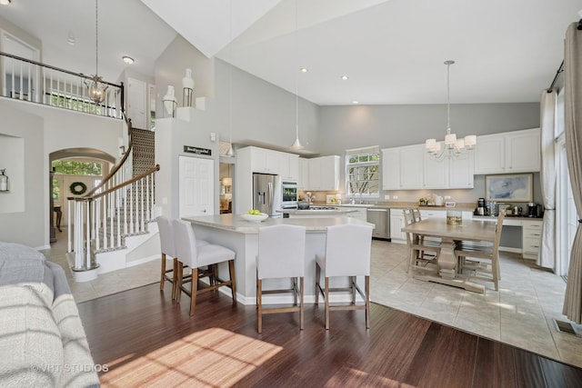 424 Bluegrass Ln, Geneva, IL 60134 - kitchen featuring appliances with stainless steel finishes, a chandelier, high vaulted ceiling, a kitchen island, and light countertops