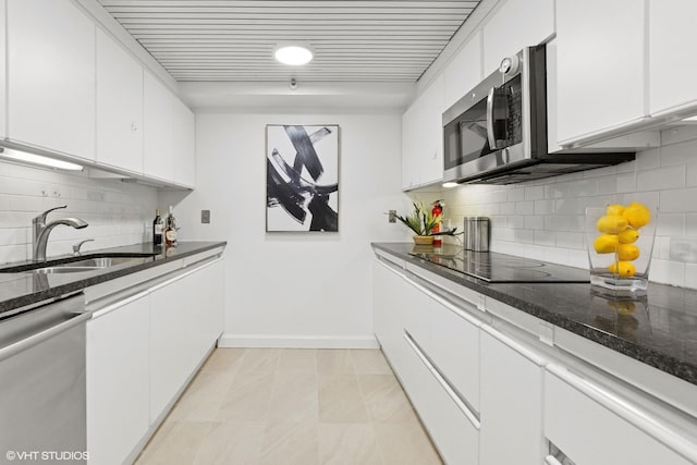 161 E Chicago Ave Unit 27C, Chicago, IL 60611 - kitchen featuring stainless steel appliances, white cabinetry, dark stone counters, and decorative backsplash