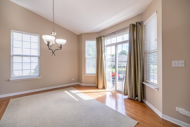 424 Riverbend Dr, Genoa, IL 60135 - unfurnished room featuring a chandelier, lofted ceiling, and light wood-type flooring