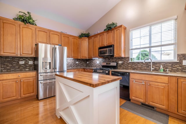 424 Riverbend Dr, Genoa, IL 60135 - kitchen with appliances with stainless steel finishes, wood counters, light wood-style floors, decorative backsplash, and vaulted ceiling