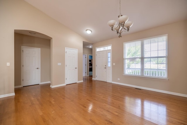 424 Riverbend Dr, Genoa, IL 60135 - foyer with a chandelier, vaulted ceiling, arched walkways, and light wood finished floors