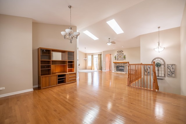 424 Riverbend Dr, Genoa, IL 60135 - unfurnished living room with a skylight, wood finished floors, high vaulted ceiling, a chandelier, and a glass covered fireplace