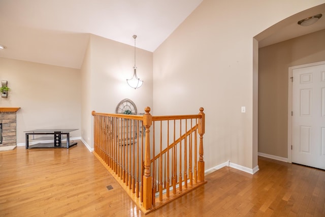 424 Riverbend Dr, Genoa, IL 60135 - hall with an upstairs landing, hardwood / wood-style flooring, lofted ceiling, and arched walkways