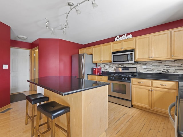 16107 Carlow Cir, Manhattan, IL 60442 - kitchen with stainless steel appliances, light wood-style floors, dark countertops, and backsplash