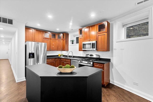 506 W Oakdale Ave Unit 1, Chicago, IL 60657 - kitchen with stainless steel appliances, brown cabinets, dark countertops, tasteful backsplash, and recessed lighting