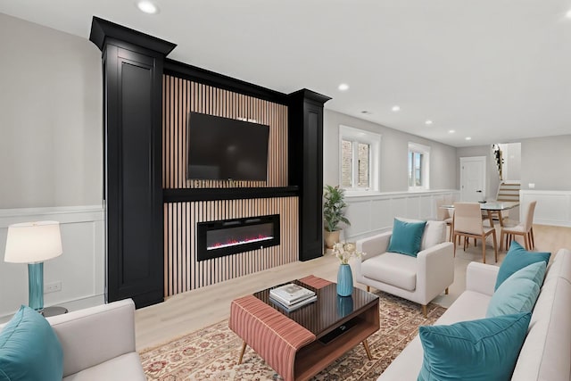 8545 Mansfield Ave, Burbank, IL 60459 - living area with a decorative wall, wainscoting, a glass covered fireplace, wood finished floors, and recessed lighting
