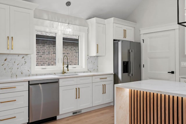 8545 Mansfield Ave, Burbank, IL 60459 - kitchen featuring stainless steel appliances, backsplash, white cabinets, light wood-type flooring, and hanging light fixtures