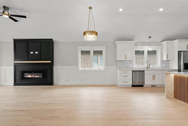 8545 Mansfield Ave, Burbank, IL 60459 - kitchen featuring stainless steel appliances, white cabinetry, light wood-type flooring, light countertops, and hanging light fixtures