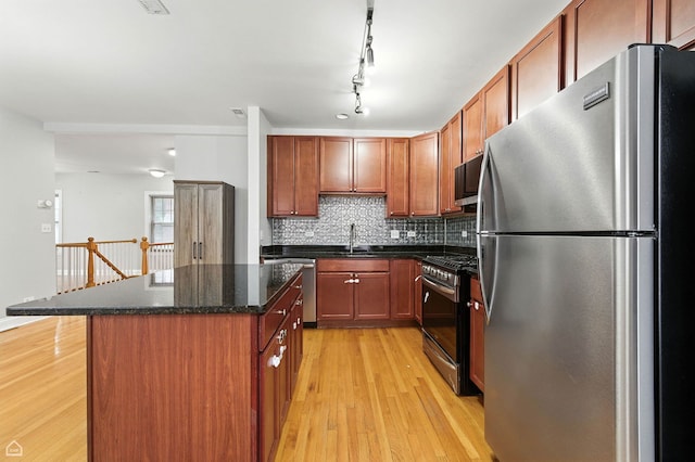 2611 W Rosemont Ave Unit A, Chicago, IL 60659 - kitchen with appliances with stainless steel finishes, light wood finished floors, a center island, and tasteful backsplash