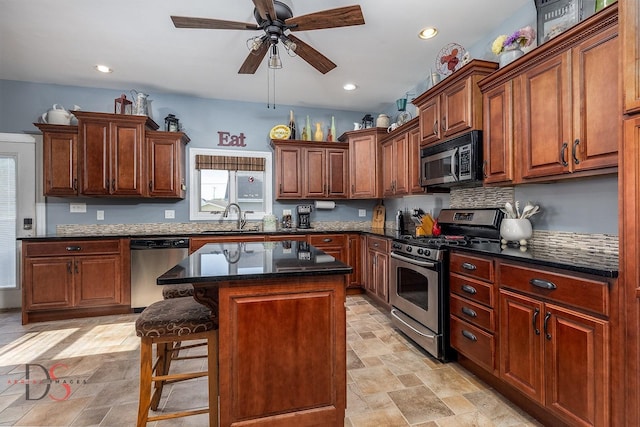 1315 W Jackson St, Ottawa, IL 61350 - kitchen with appliances with stainless steel finishes, ceiling fan, tasteful backsplash, a breakfast bar, and a center island