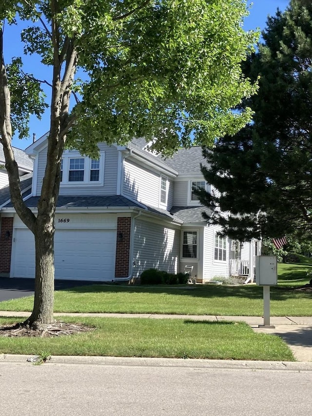 1669 Saint Ann Dr, Hanover Park, IL 60133 - view of front of home featuring a front yard, an attached garage, brick siding, and a shingled roof