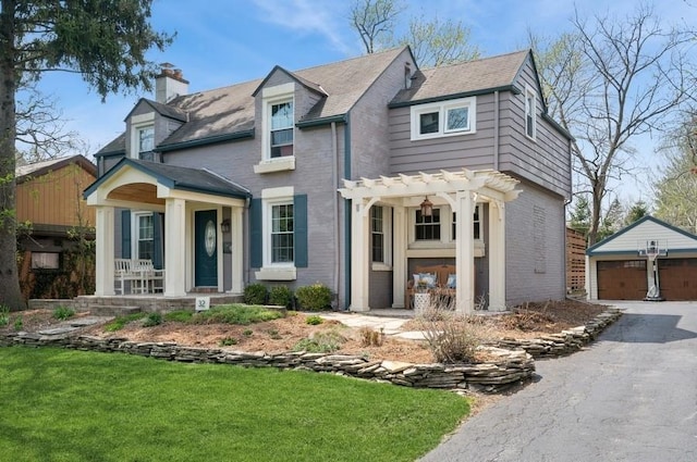 32 Valley Rd, Highland Park, IL 60035 - view of front facade featuring an outdoor structure, brick siding, a detached garage, a pergola, and a chimney