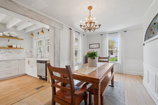 32 Valley Rd, Highland Park, IL 60035 - dining room with a chandelier, light wood-type flooring, a wainscoted wall, beamed ceiling, and crown molding