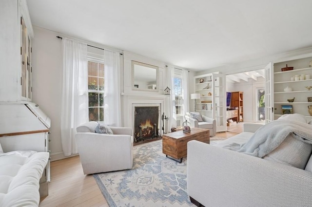 32 Valley Rd, Highland Park, IL 60035 - living area with plenty of natural light, light wood-type flooring, a warm lit fireplace, and built in shelves