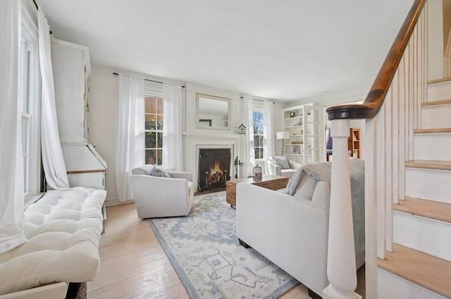 32 Valley Rd, Highland Park, IL 60035 - living room featuring light wood-type flooring, stairway, and a lit fireplace