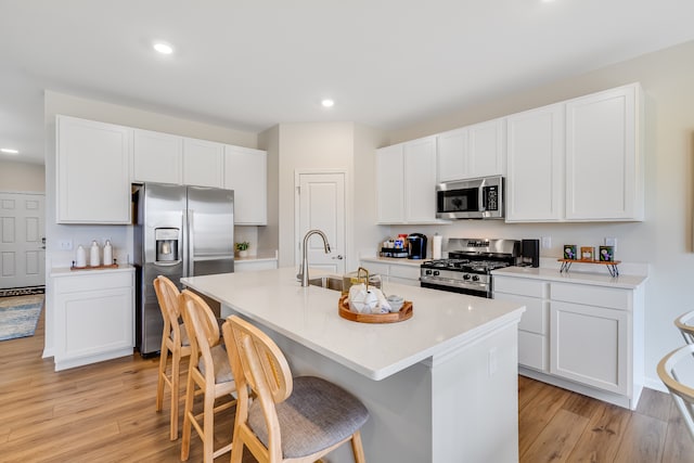1039 Greenleaf St, Sycamore, IL 60178 - kitchen with appliances with stainless steel finishes, light wood-style flooring, a breakfast bar, a kitchen island with sink, and recessed lighting