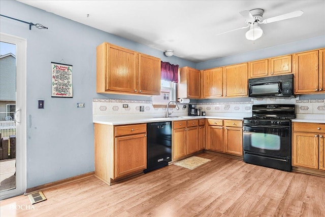 2006 Westmore Grove Dr, Plainfield, IL 60586 - kitchen featuring black appliances, light countertops, light wood-style flooring, decorative backsplash, and a ceiling fan