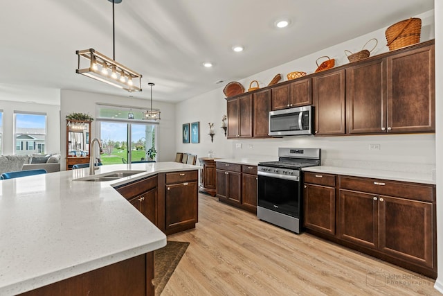 1664 Windsor Rd, Pingree Grove, IL 60140 - kitchen with appliances with stainless steel finishes, light wood-type flooring, recessed lighting, dark brown cabinetry, and pendant lighting