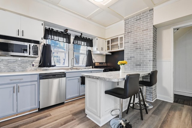 434 4th Ave, Joliet, IL 60433 - kitchen featuring stainless steel appliances, a peninsula, backsplash, a breakfast bar, and wood finished floors