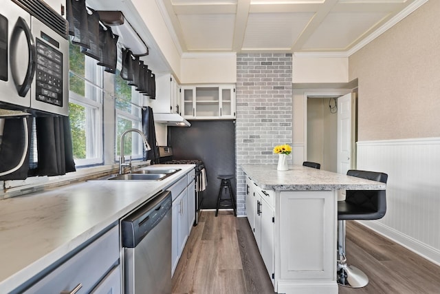 434 4th Ave, Joliet, IL 60433 - kitchen featuring appliances with stainless steel finishes, a breakfast bar, light countertops, wainscoting, and dark wood-style flooring
