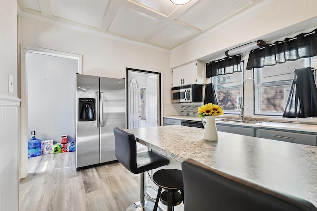 434 4th Ave, Joliet, IL 60433 - kitchen featuring appliances with stainless steel finishes, light wood-style floors, a breakfast bar, light countertops, and crown molding