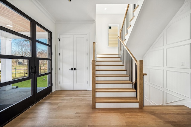 1206 Isabella St, Wilmette, IL 60091 - stairway featuring french doors, healthy amount of natural light, wood finished floors, recessed lighting, and crown molding