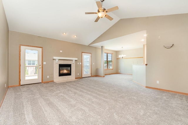 313 W Burlington Dr, Maple Park, IL 60151 - unfurnished living room featuring a tiled fireplace, a chandelier, vaulted ceiling, light colored carpet, and a ceiling fan
