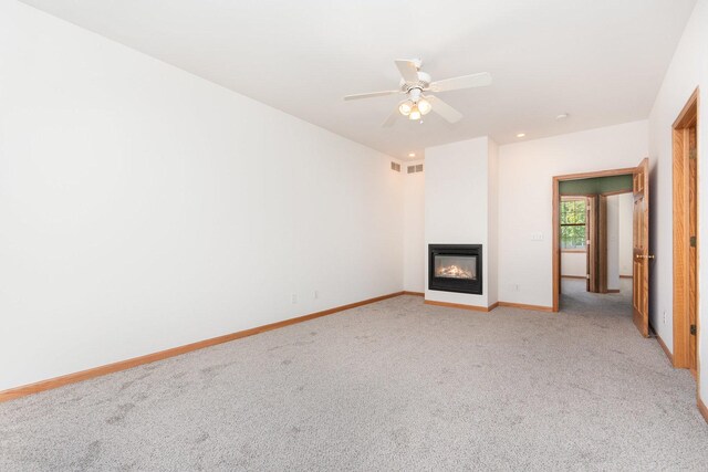 313 W Burlington Dr, Maple Park, IL 60151 - unfurnished living room featuring light colored carpet, a glass covered fireplace, and a ceiling fan