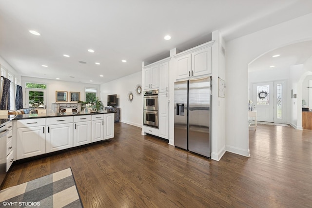 1000 S Madison Ave, La Grange, IL 60525 - kitchen with appliances with stainless steel finishes, arched walkways, dark countertops, dark wood-style floors, and recessed lighting