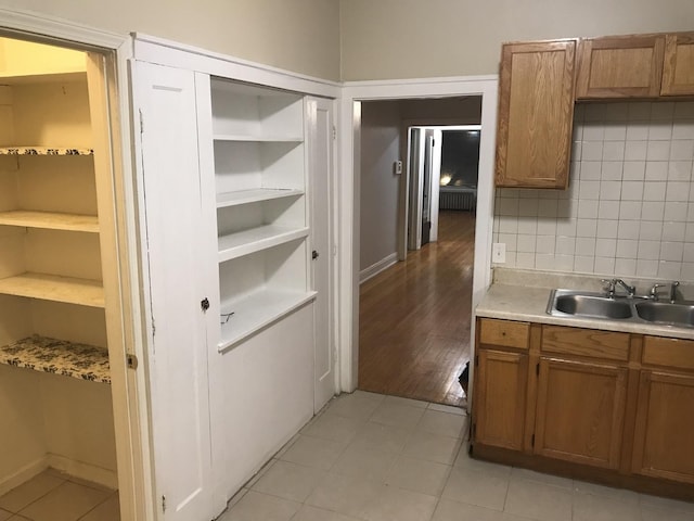 kitchen with brown cabinetry, light countertops, and light tile patterned floors