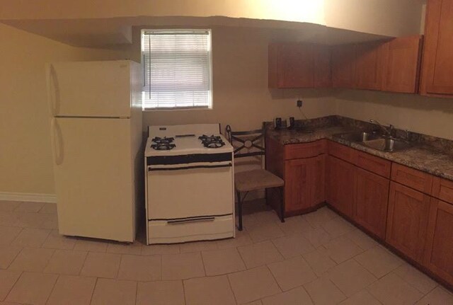 kitchen featuring white appliances, brown cabinetry, and light tile patterned flooring